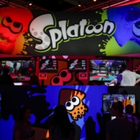 Attendees play Nintendo\'s Splatoon game during the E3 Electronic Entertainment Expo in Los Angeles in 2014. The latest installment, Splatoon 3, topped initial domestic sales of any Switch title in Japan. | BLOOMBERG