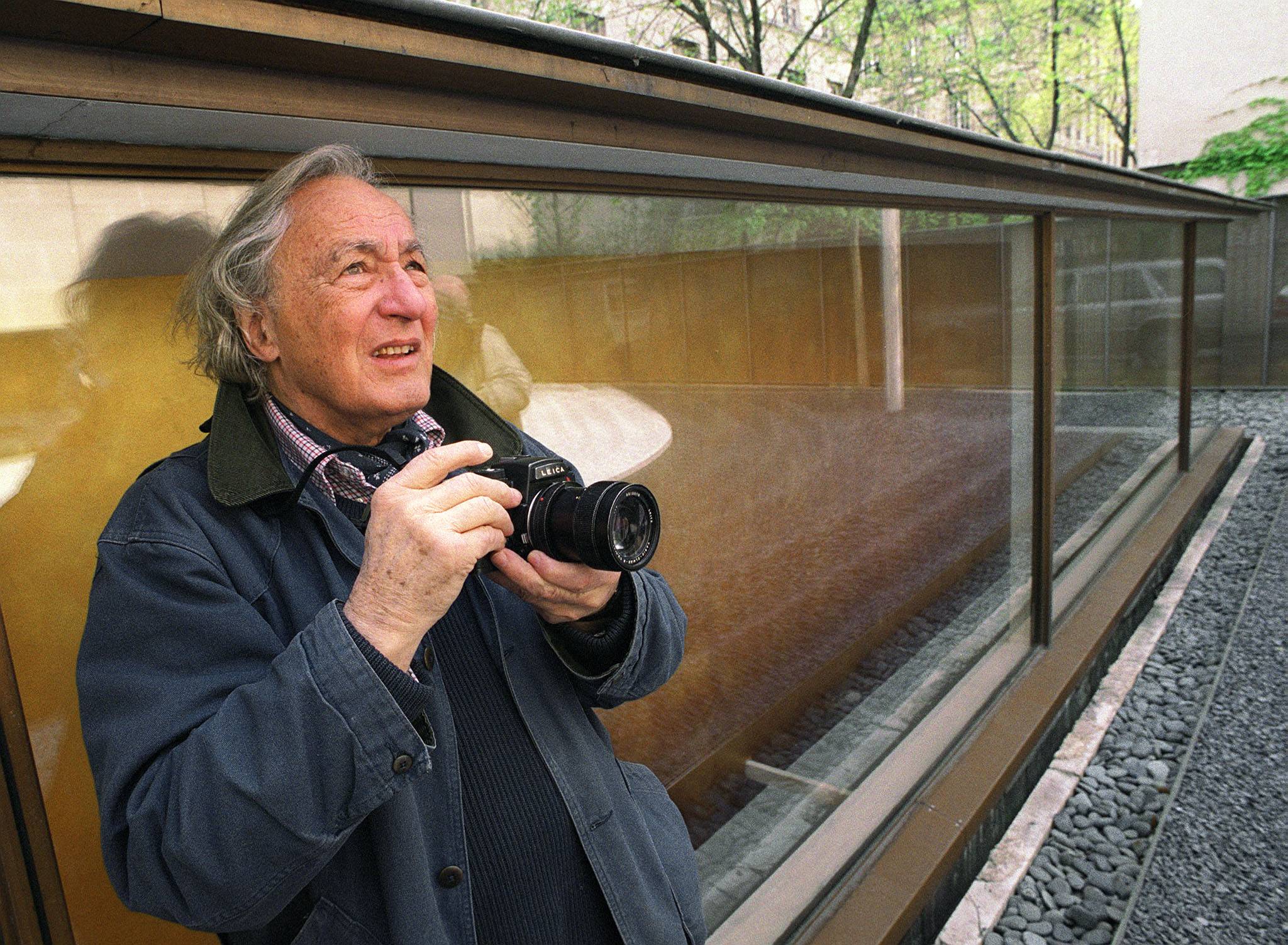 Photographer William Klein prepares to take a photograph of a poster advertising an exhibition of his work at The Maison Europeenne de la Photographie in 2002. | AFP-JIJI