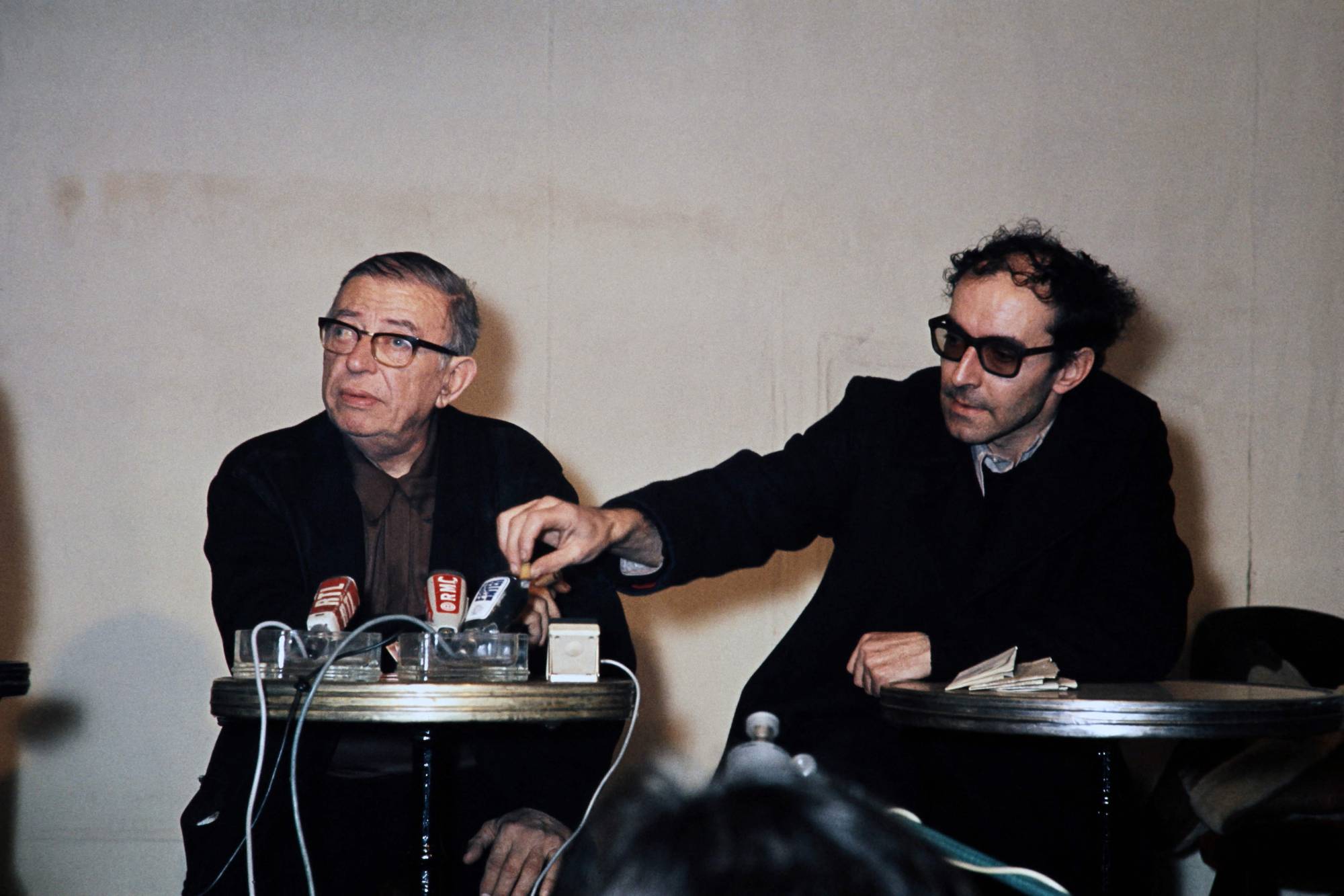 Philosopher and writer Jean-Paul Sartre (left) and Godard answer questions from the media in Paris in 1971. | AFP-JIJI