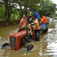 Residents are evacuated to safer places in a tractor after heavy rains caused flooding in a residential area of Bengaluru in November 2021.  | REUTERS 