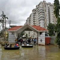 People use boats to move through a water-logged neighborhood following torrential rains in Bengaluru on Sept. 7. | REUTERS 