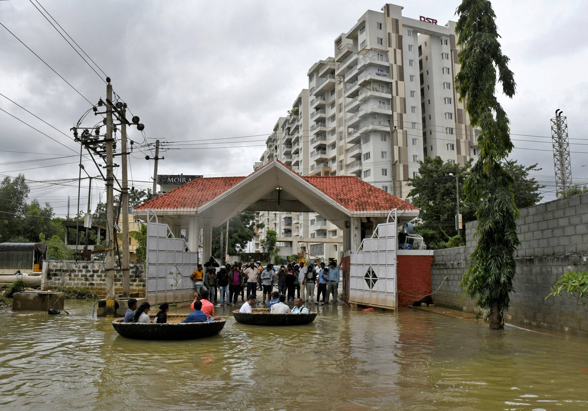 People use boats to move through a water-logged neighborhood following torrential rains in Bengaluru on Sept. 7. | Reuters 