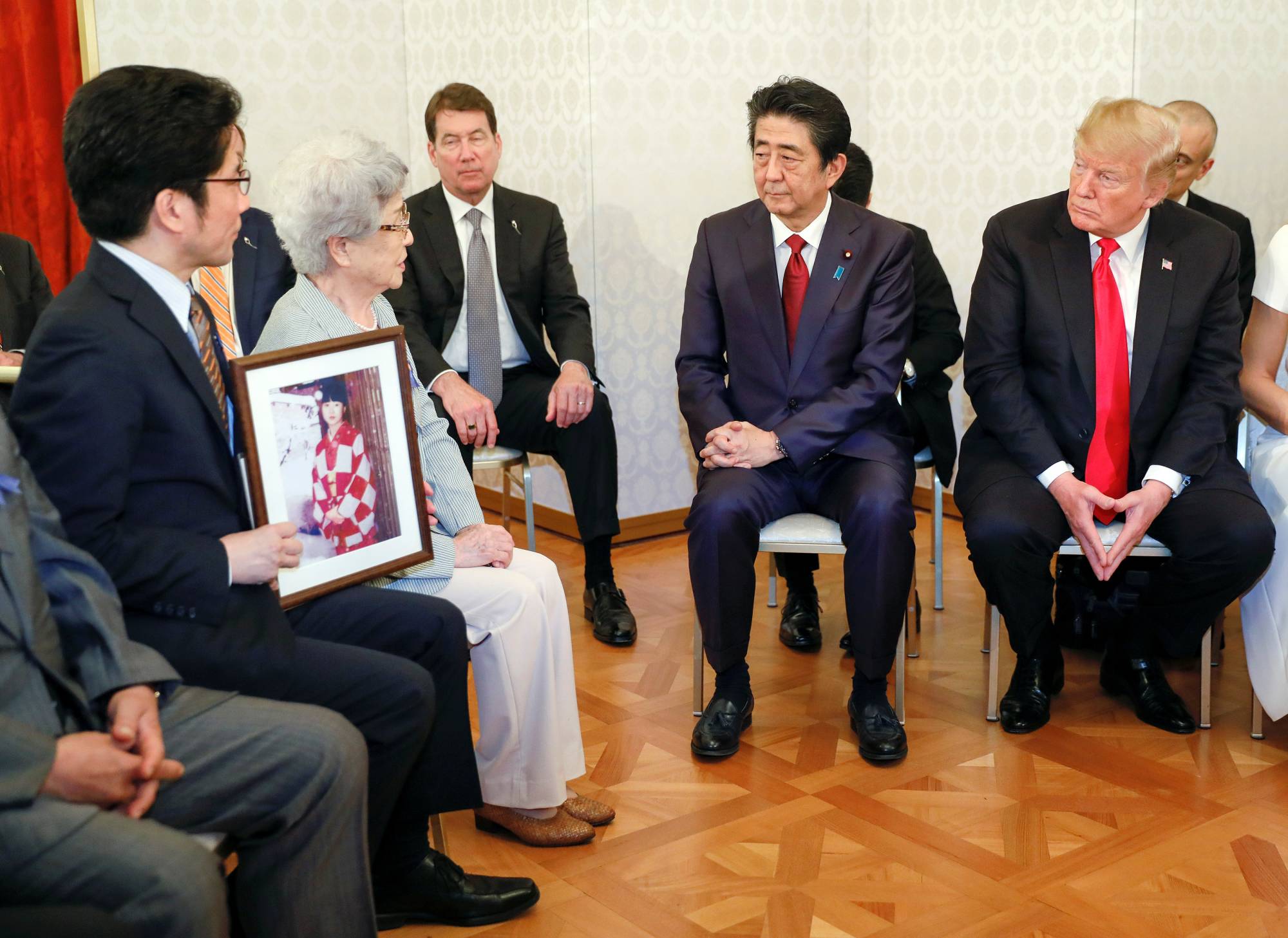 Then-Prime Minister Shinzo Abe and then-U.S. President Donald Trump meet with Sakie Yokota, mother of Megumi Yokota, who was kidnapped by North Korean agents at the age of 13 in 1977, and other families of Japanese abductees by North Korea in Tokyo in May 2019.   | POOL / VIA REUTERS