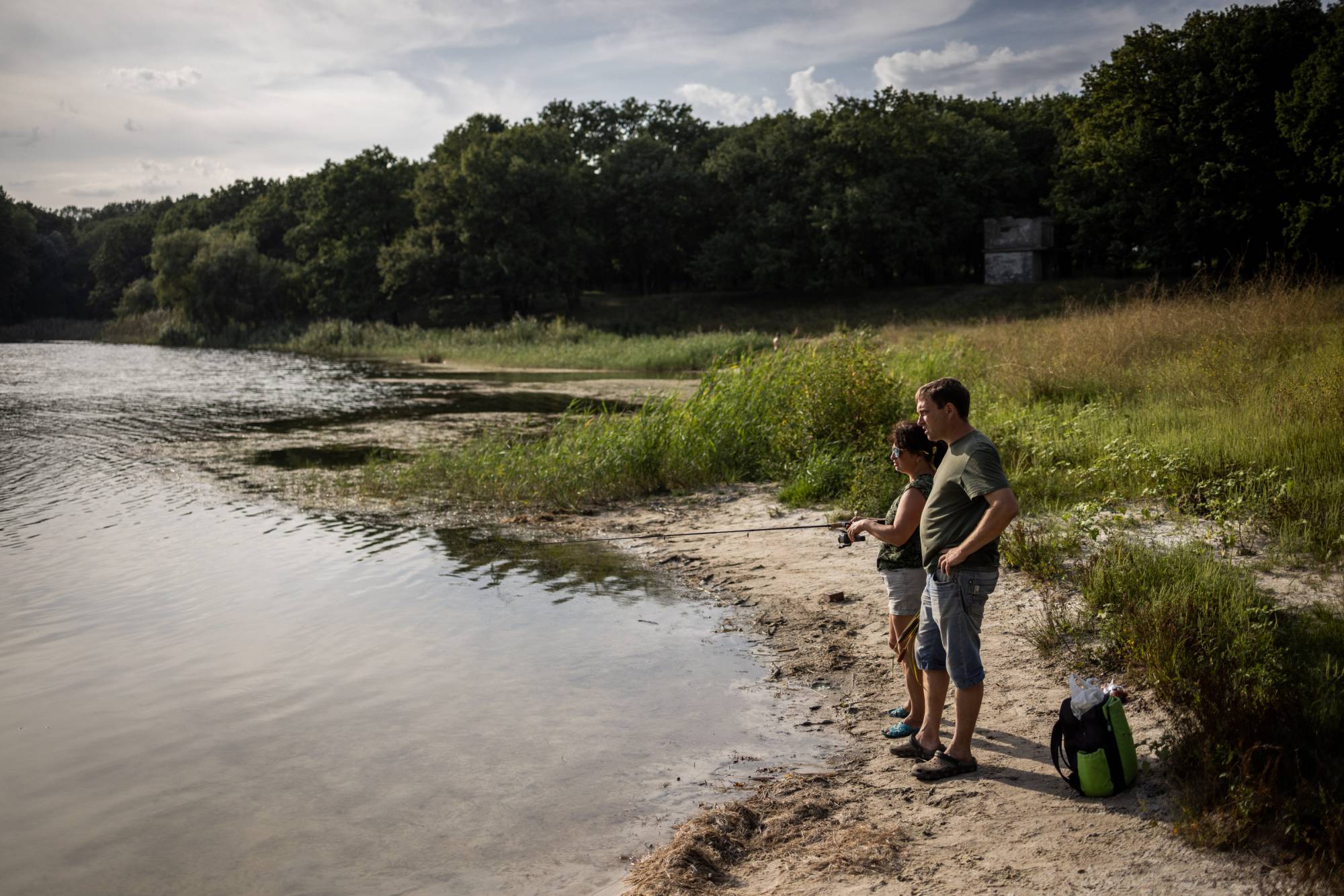 Alex Khainus, a supporter of Ukraine in a region with many separatists and Russian sympathizers, with a friend fishing on a pond in Chasiv Yar, Ukraine, on Aug. 25. | Jim Huylebroek / The New York Times