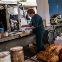 Butcher Olena Dmitriieva and her husband at her market stall in Chasiv Yar, Ukraine, on Aug. 25.  | JIM HUYLEBROEK / THE NEW YORK TIMES