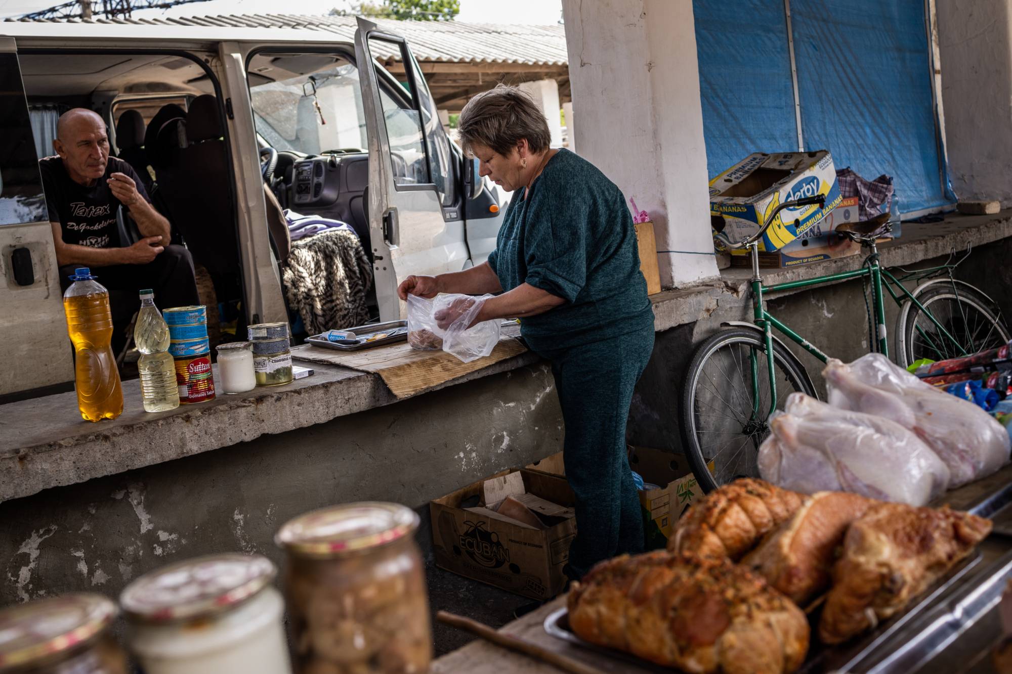Butcher Olena Dmitriieva and her husband at her market stall in Chasiv Yar, Ukraine, on Aug. 25. | Jim Huylebroek / The New York Times