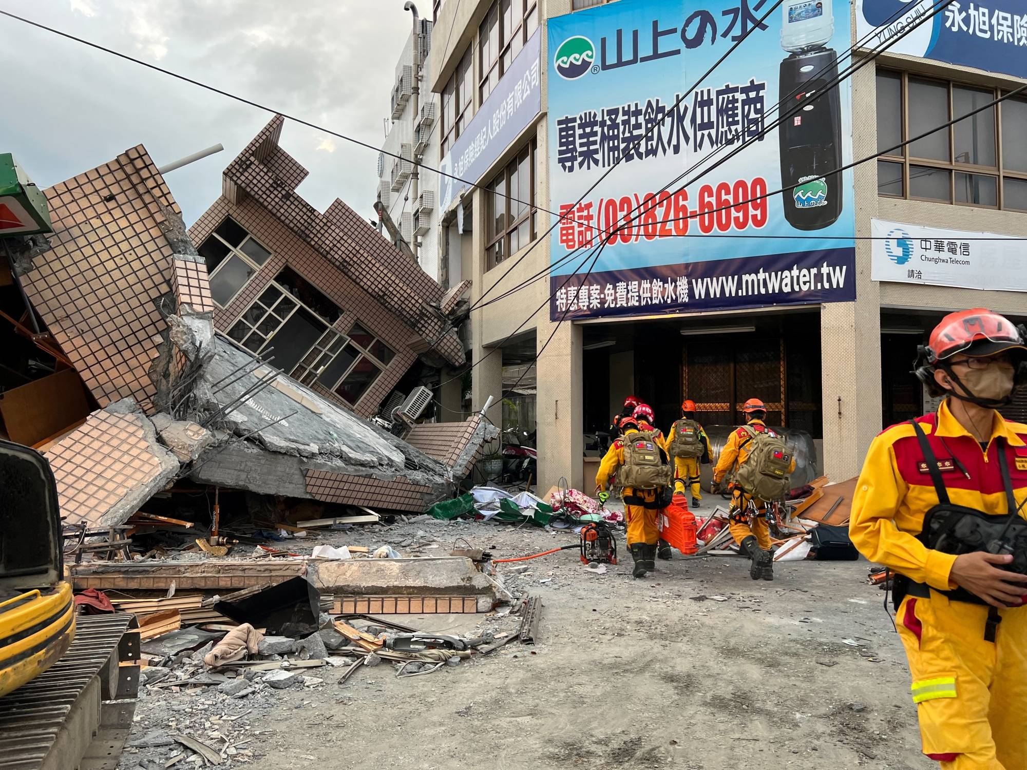Firefighters work at the site where a building collapsed following a 6.8-magnitude earthquake, in Yuli, Taiwan, on Sunday. | TAIWAN'S 0918 EARTHQUAKE CENTRAL EMERGENCY OPERATIONS CENTER / VIA REUTERS
