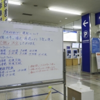 A signboard shows cancellations of ferry operations in the city of Niigata on Tuesday as Typhoon Nanmadol moved through the area. | KYODO