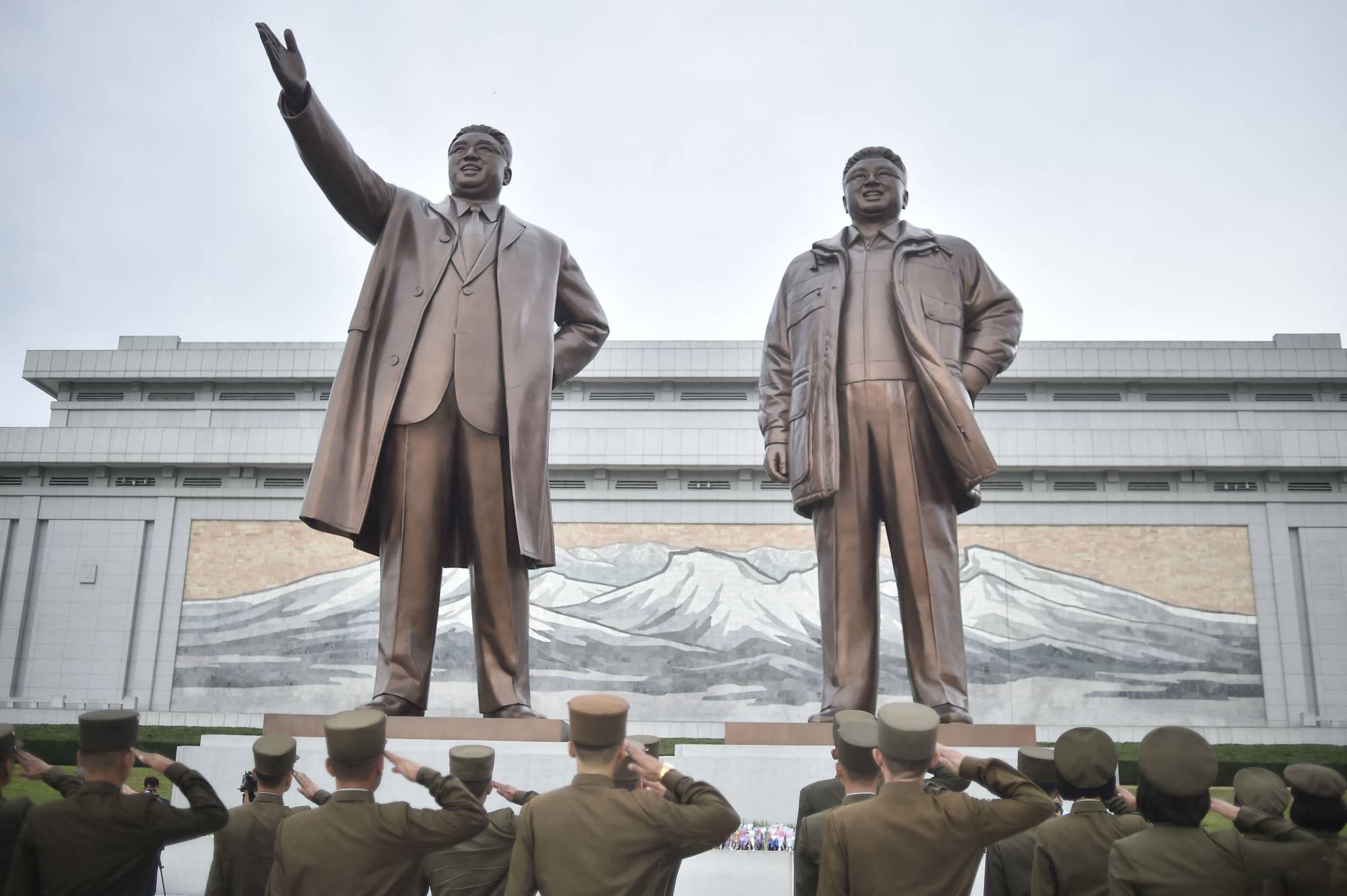 Korean People's Army personnel pay their respects before the statues of late North Korean leaders Kim Il Sung and Kim Jong Il at Mansu Hill in Pyongyang on Aug. 25. | AFP-JIJI