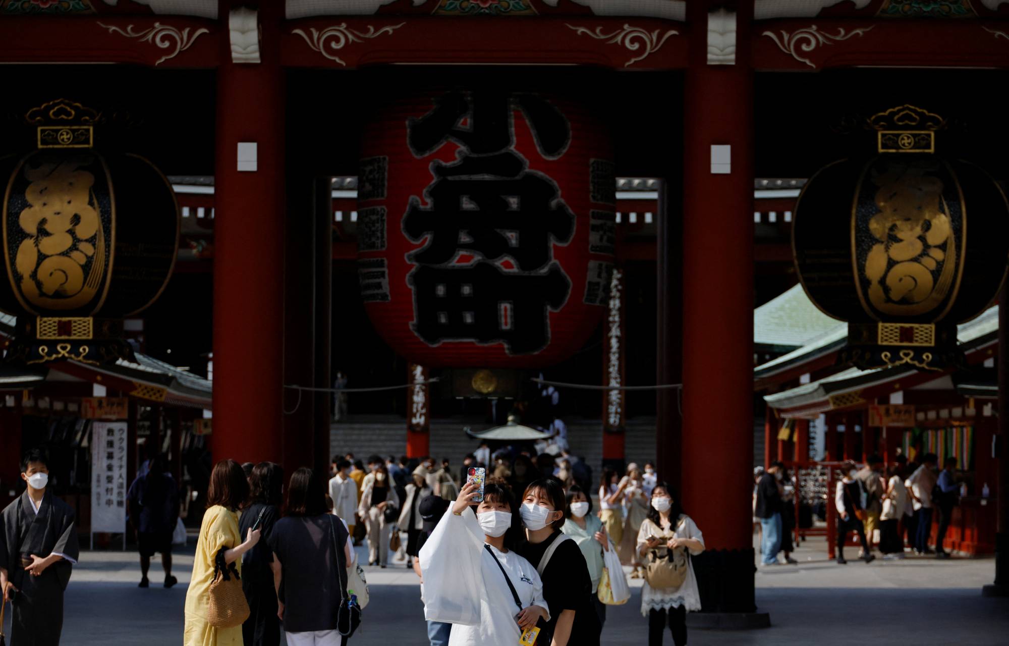 Visitors take selfie photos at Tokyo's Asakusa district. Japan has announced a major policy shift, allowing visa-free, independent tourism and abolishing a daily arrival cap as of Oct. 11. | REUTERS