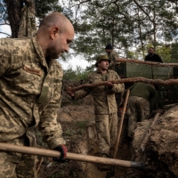 Ukrainian soldiers dig trenches in front-line positions recently recaptured from Russian forces near Oskil, Ukraine, on Saturday.  | NICOLE TUNG / THE NEW YORK TIMES