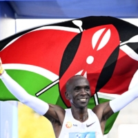 Eliud Kipchoge celebrates after winning the Berlin Marathon on Sunday, beating his own world record in the process. | AFP-JIJI