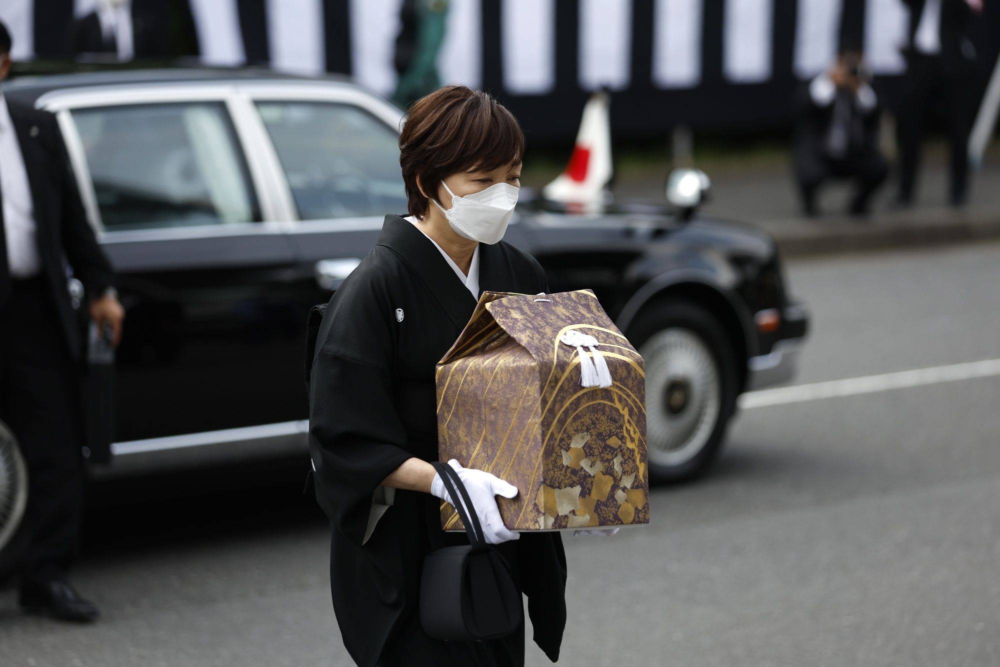 Former Prime Minister Sinzo Abe's wife, Akie, arrives for the state funeral of her husband with his cinerary urn at the Nippon Budokan in Tokyo on Tuesday.   | BLOOMBERG