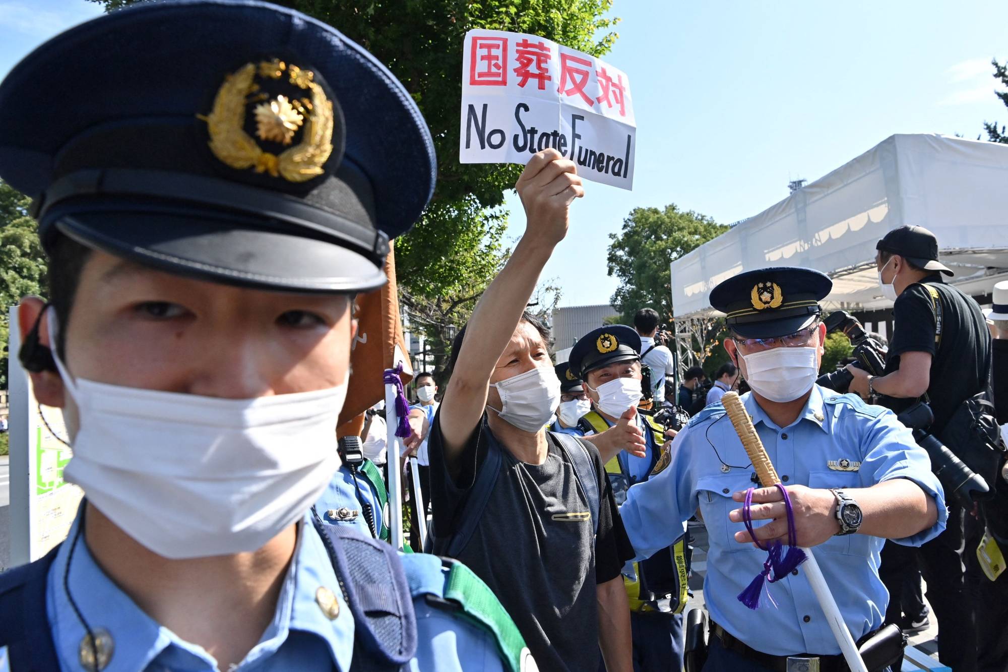 A protester is surrounded by police near the Nippon Budokan ahead of the state funeral | AFP-JIJI