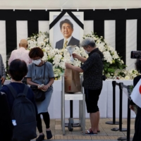 Mourners offer flowers at an altar outside Nippon Budokan. | REUTERS