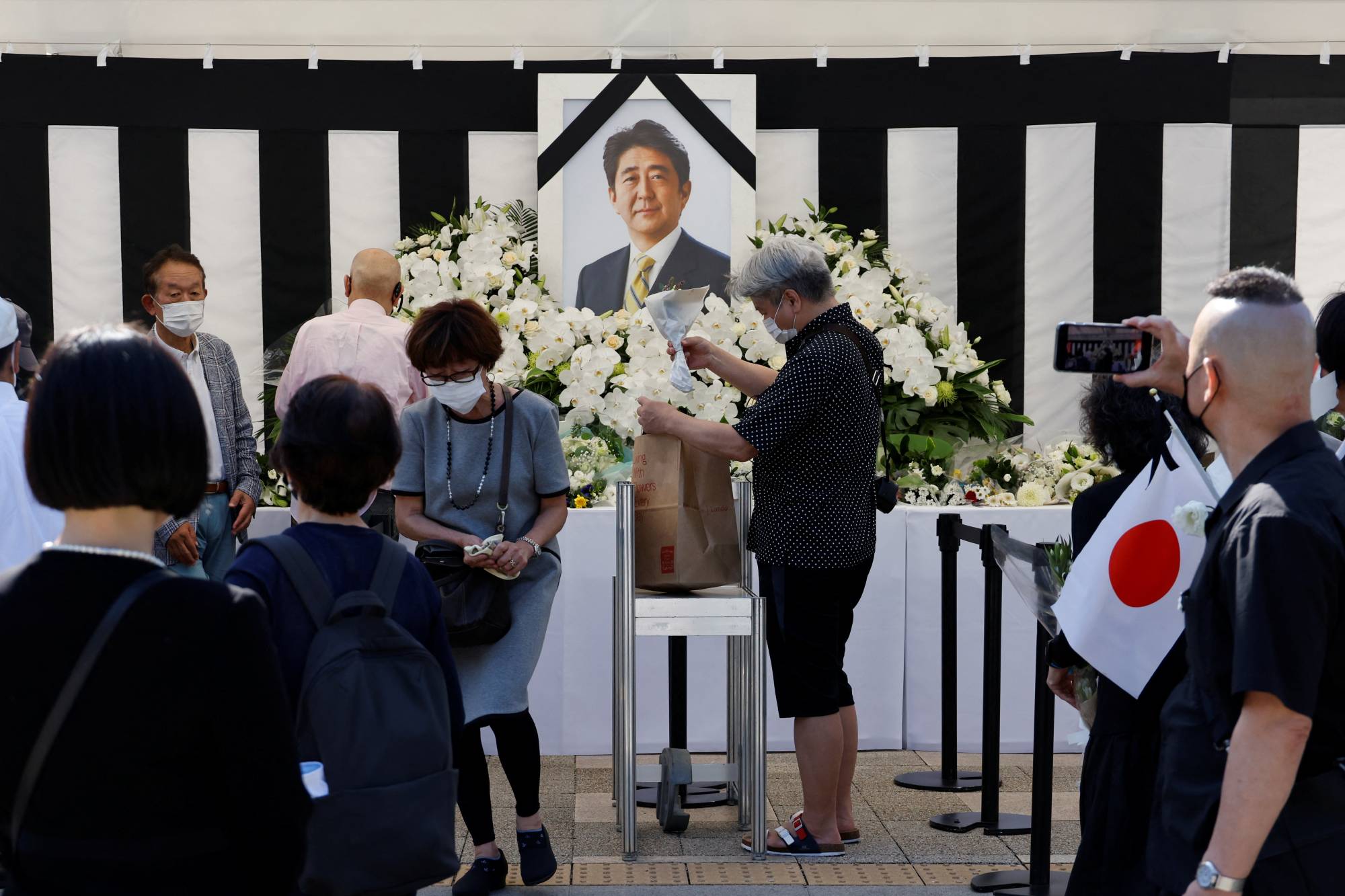 Mourners offer flowers at an altar outside Nippon Budokan. | REUTERS