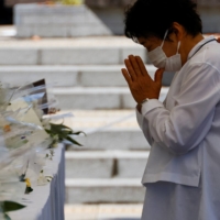 A visitor prays in front of the altar outside the Budokan | REUTERS