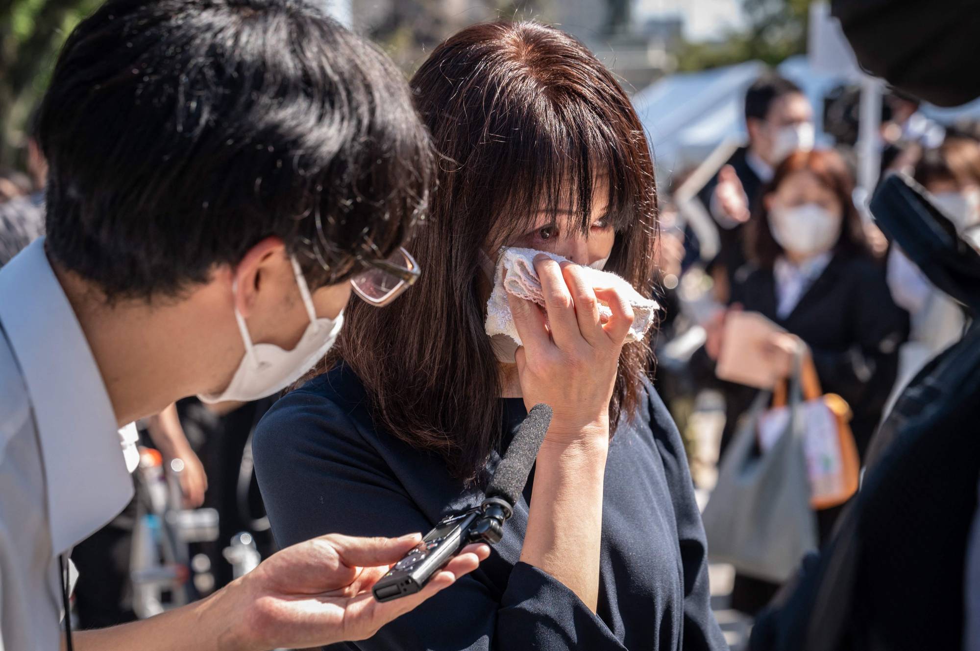 A woman cries during an interview near the funeral venue | AFP-JIJI