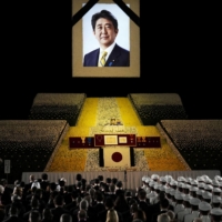 A portrait of former Prime Minister Shinzo Abe hangs above the stage during the state funeral. | POOL / VIA REUTERS