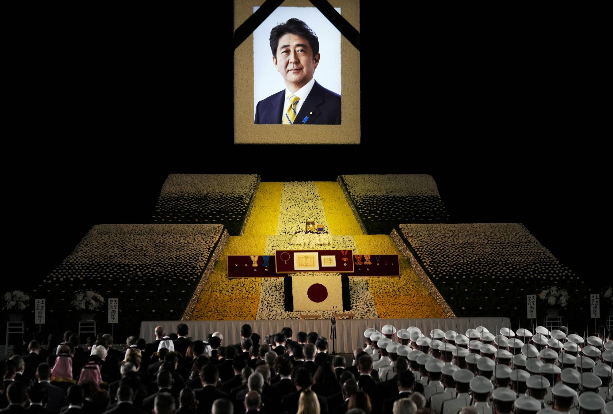 A portrait of former Prime Minister Shinzo Abe hangs above the stage during the state funeral. | POOL / VIA REUTERS