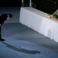 Prime Minister Fumio Kishida bows after laying flowers on the funeral altar. | POOL / VIA REUTERS