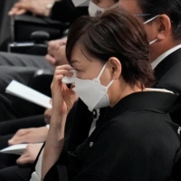 Akie Abe wipes away tears during the state funeral of her husband. | POOL / VIA REUTERS