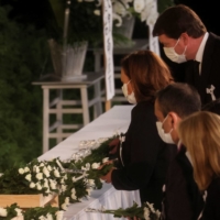 U.S. Vice President Kamala Harris and other officials place flowers in front of the funeral altar | POOL / VIA REUTERS