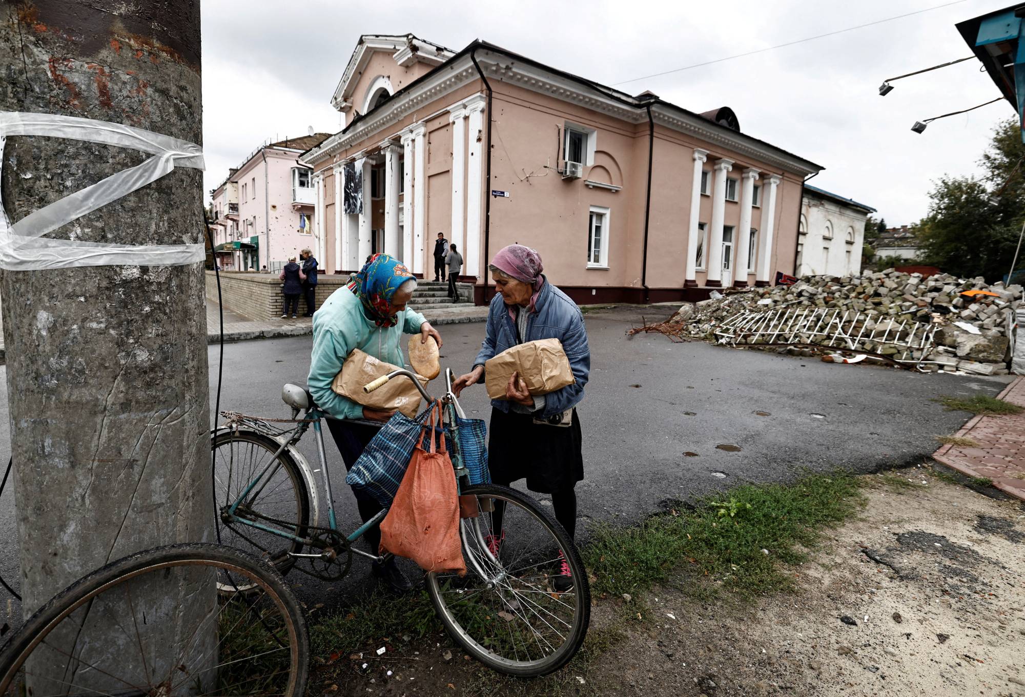 Two women who received humanitarian aid in the recently liberated town of Izium, in Kharkiv region, Ukraine, on Tuesday. | REUTERS