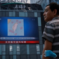A screen in Beijing on Aug. 3 shows a news broadcast featuring a map of locations around Taiwan where the Chinese military was set to conduct exercises and training activities. | REUTERS