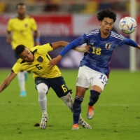 Japan\'s Kaoru Mitoma contends for the ball with Ecuador\'s Byron Castillo in Dusseldorf, Germany, on Tuesday. | REUTERS