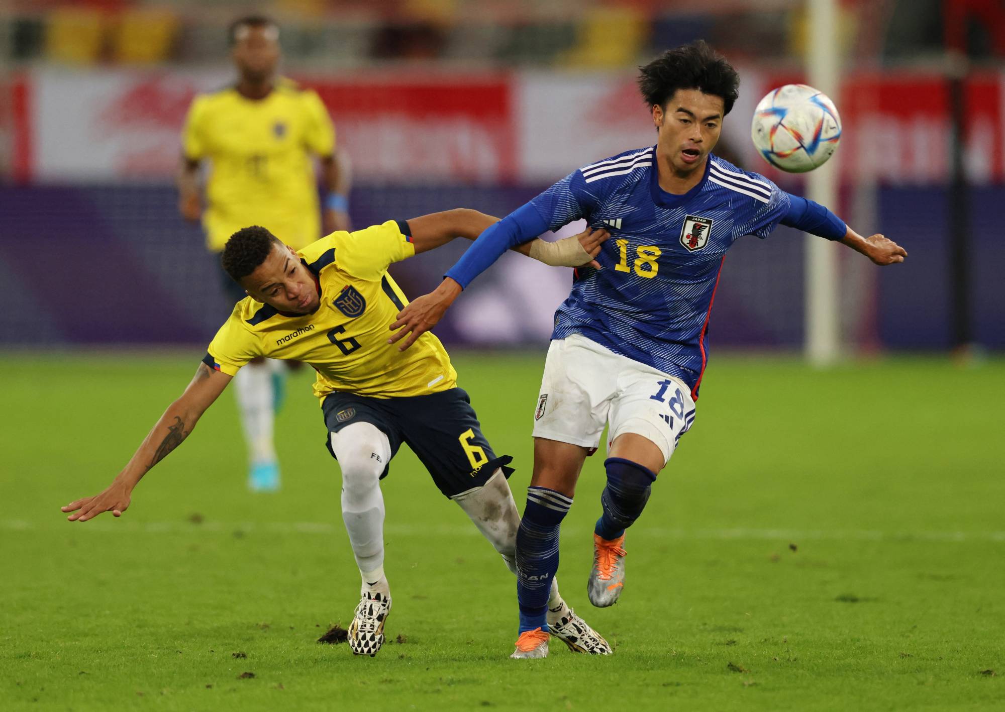 Japan's Kaoru Mitoma contends for the ball with Ecuador's Byron Castillo in Dusseldorf, Germany, on Tuesday. | REUTERS