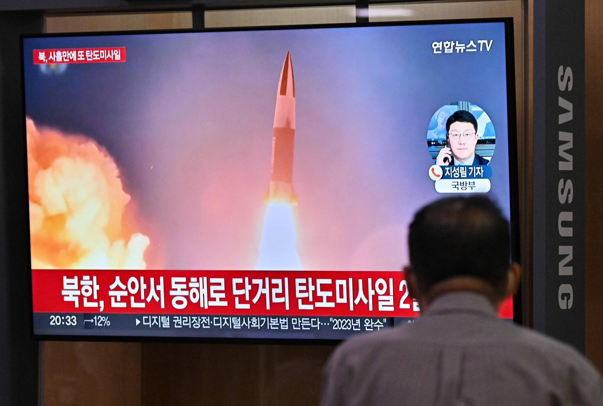 A man watches a television screen showing a news broadcast with file footage of a North Korean missile test, at the main railway station in Seoul on Wednesday. | AFP-JIJI