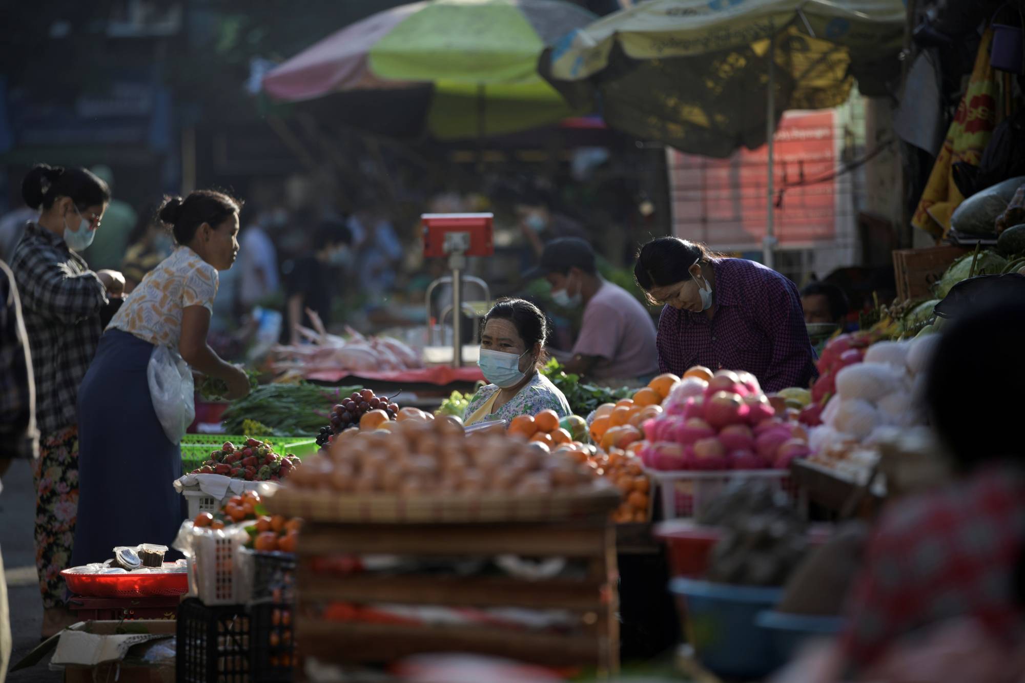 People shop at a market after army seized power in a coup in Yangon, Myanmar, in February 2021. | REUTERS