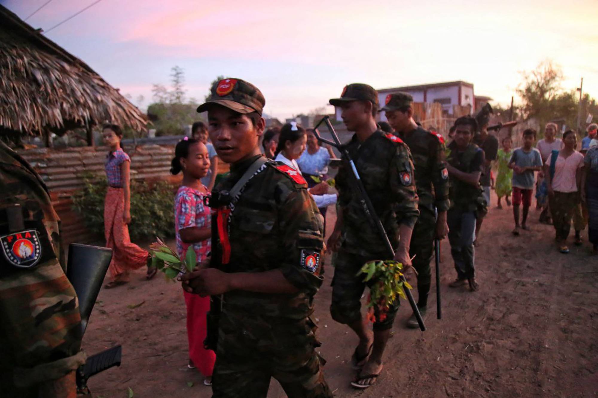 Anti-coup fighters are given flowers by local residents in a township in Myanmar's northwestern Sagaing region on Aug. 16. | AFP-JIJI