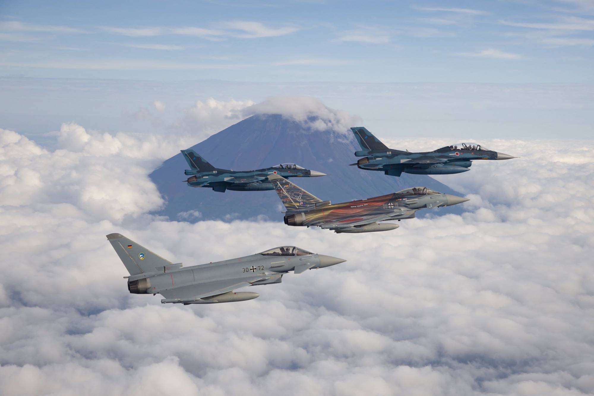 Japanese F-2 fighter jets fly with German Air Force Eurofighters past Mount Fuji during joint military drills held Wednesday. | DEFENSE MINISTRY / VIA AFP-JIJI