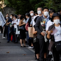 Mourners line up near the Nippon Budokan hall in Tokyo to pay their final respects to former Prime Minister Shinzo Abe on Tuesday, the day of his state funeral. | REUTERS
