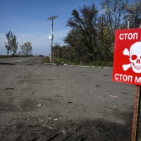 A sign in the city of Izyum warns of landmines. The area in eastern Ukraine was recently liberated by from Russian forces.   | AFP-JIJI