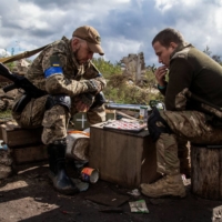Ukrainian soldiers play a game of checkers near a front-line position opposite Russian forces in the Kharkiv region of Ukraine on Sept. 24.   | REUTERS