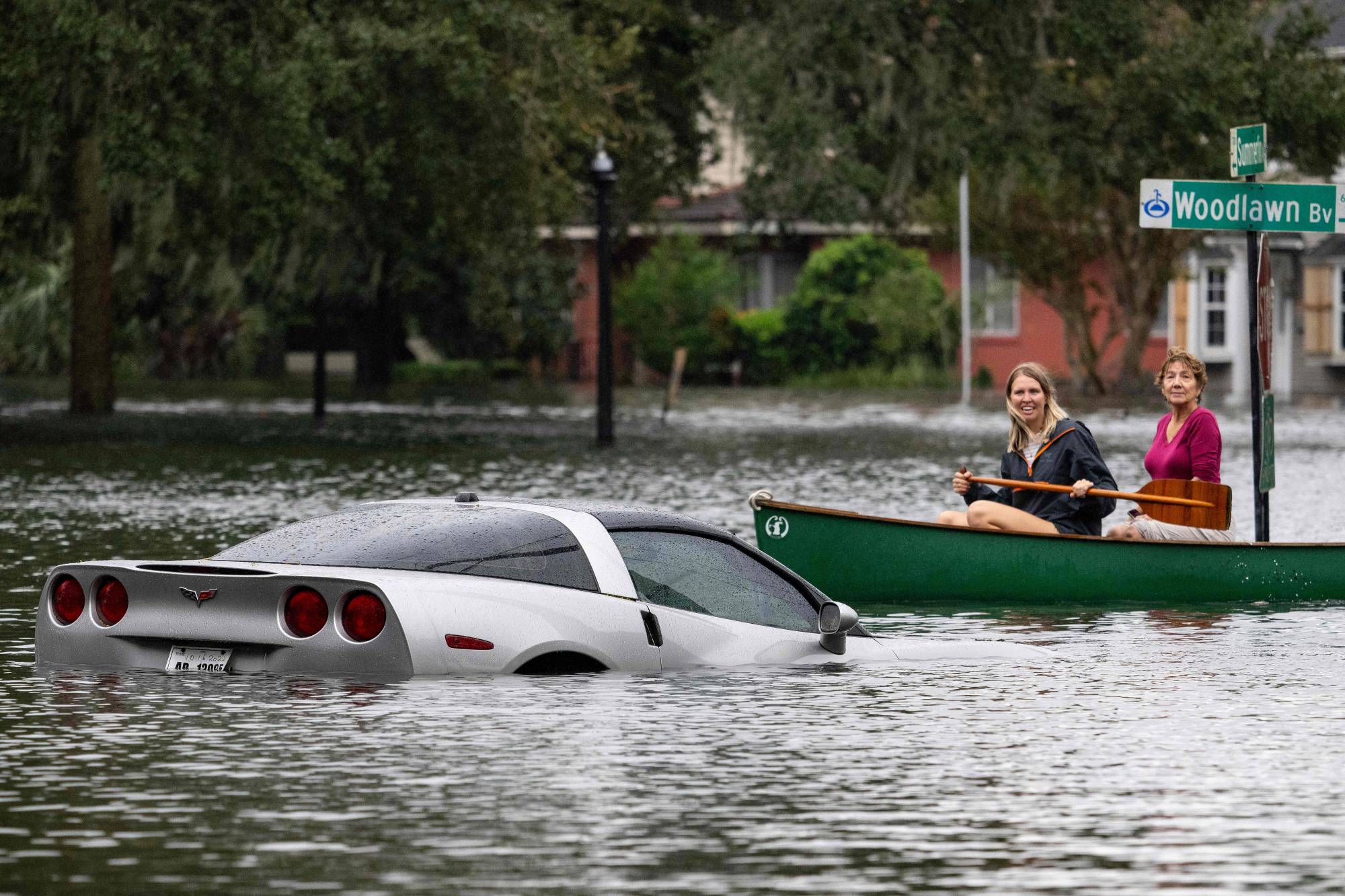 People paddle by in a canoe next to a submerged Chevy Corvette in the aftermath of Hurricane Ian in Orlando, Florida, on Thursday. | AFP-JIJI