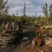 Ukrainian soldiers check for salvageable parts on destroyed Russian military vehicles Saturday. After a series of humiliating retreats, Putin clearly sees the threat of his nuclear arsenal as a way to instill fear.  | IVOR PRICKETT / THE NEW YORK TIMES