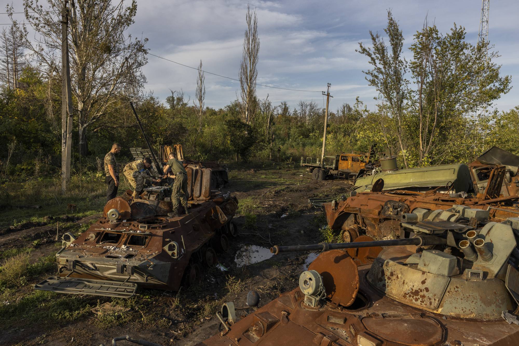 Ukrainian soldiers check for salvageable parts on destroyed Russian military vehicles Saturday. After a series of humiliating retreats, Putin clearly sees the threat of his nuclear arsenal as a way to instill fear. | Ivor Prickett / The New York Times
