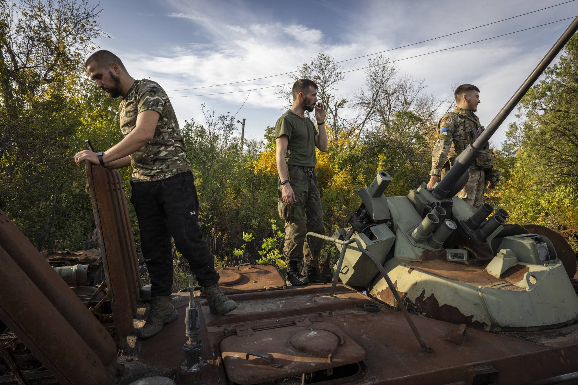 Ukrainian soldiers check for salvageable parts on destroyed and abandoned Russian military vehicles in Izium, Ukraine, on Saturday. | Ivor Prickett / The New York Times