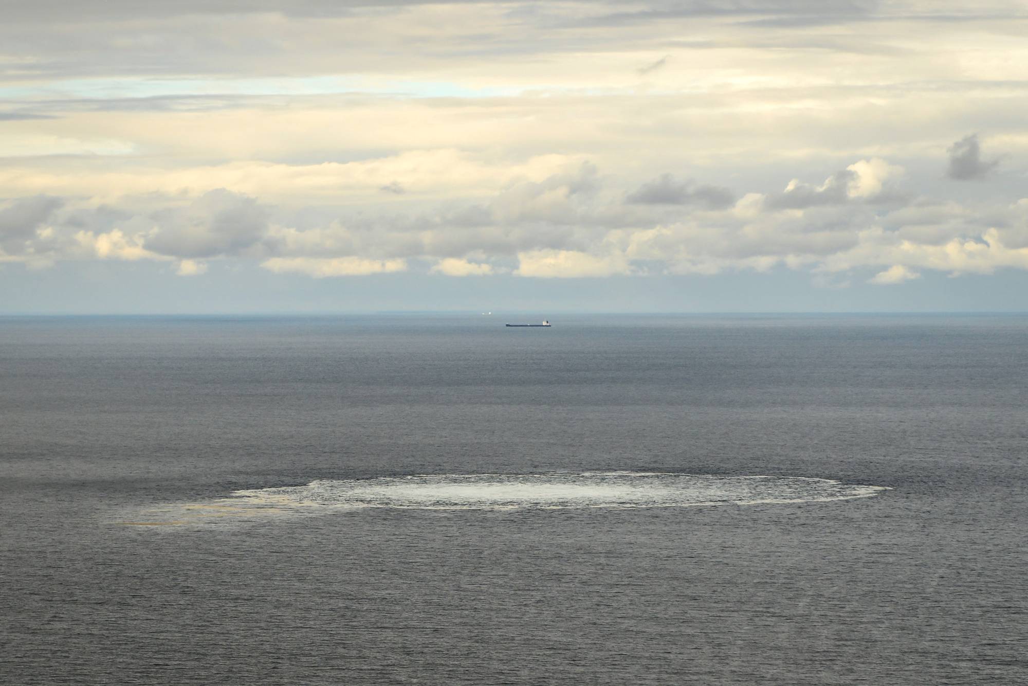 A Danish defense aircraft flies near one of the Nord Stream gas leaks in the Baltic Sea on Friday.   | DANISH DEFENSE COMMAND / VIA REUTERS  