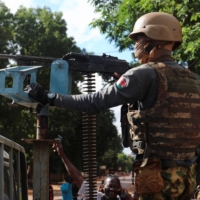 Burkina Faso junta\'s soldiers stand guard in an armored vehicle in the capital city, Ouagadougou, on Sunday.   | REUTERS