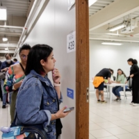 Voters wait in line to cast ballots in Sao Paulo on Sunday. | BLOOMBERG 