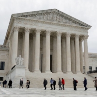 People walk across the plaza of the U.S. Supreme Court building on the first day of the court\'s new term in October 2022. | REUTERS