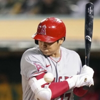 Angels designated hitter Shohei Ohtani is hit by a pitch in the third inning against the Athletics in Oakland, California, on Tuesday. | KYODO