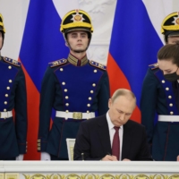 Russian President Vladimir Putin signs treaties formally annexing the Ukrainian regions of Lugansk, Donetsk, Kherson and Zaporizhzhia at the Kremlin on Friday.  | SPUTNIK / VIA AFP-JIJI