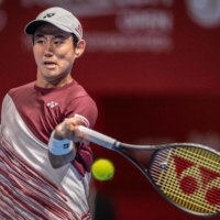 Yoshihito Nishioka hits a return against Miomir Kecmanovic during their Japan Open match on Wednesday. | AFP-JIJI