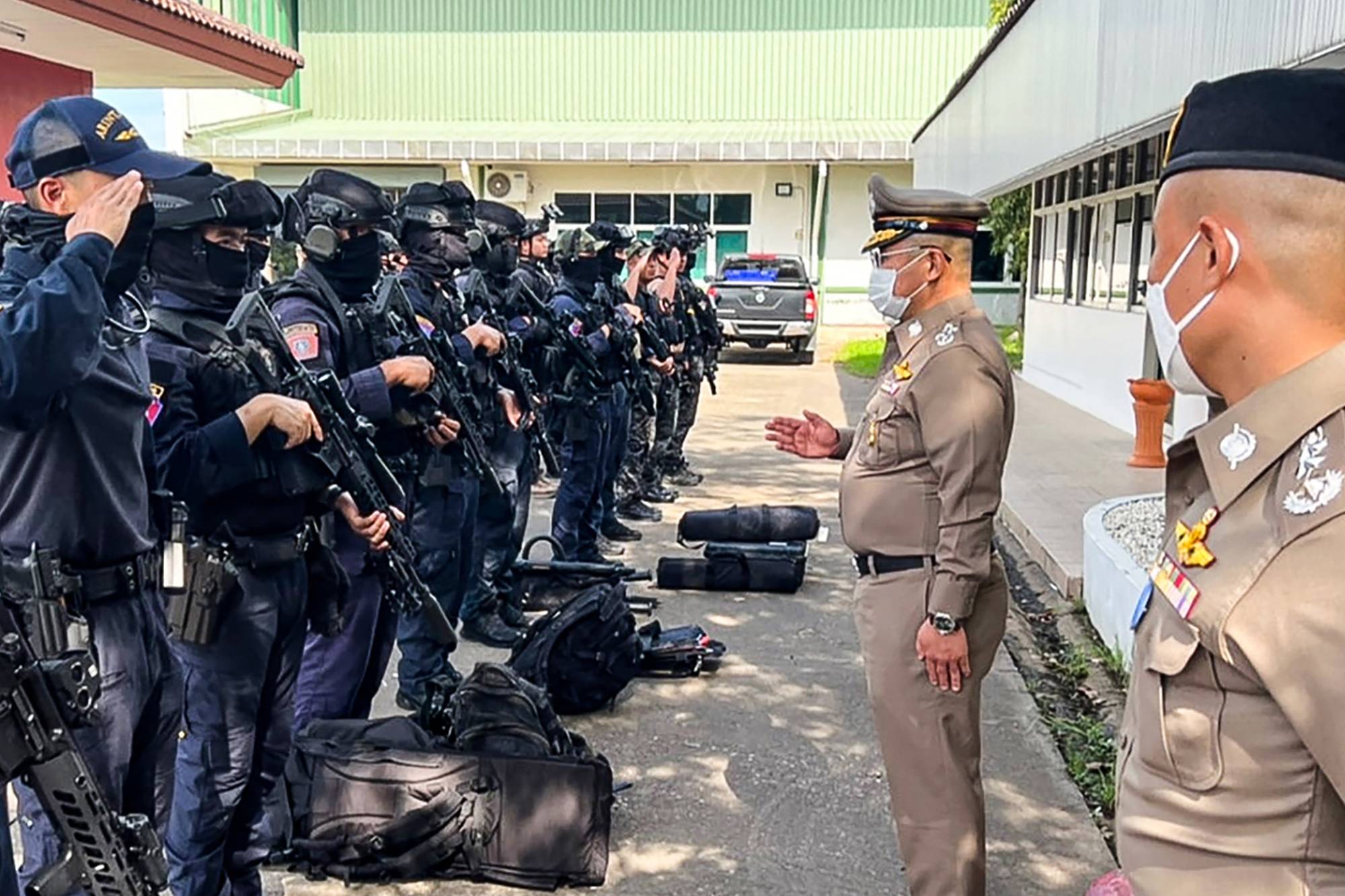 National Police Chief, Damrongsak Kittiprapat (second from right), speaking with a police operation team following an attack on a nursery in the northern Thai province of Nong Bua Lam Phu on Thursday. | ROYAL THAI POLICE / VIA AFP-JIJI